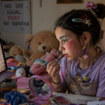 niña imitando a una influencer con una tablet usando maquillaje y objetos que tiene en su habitación